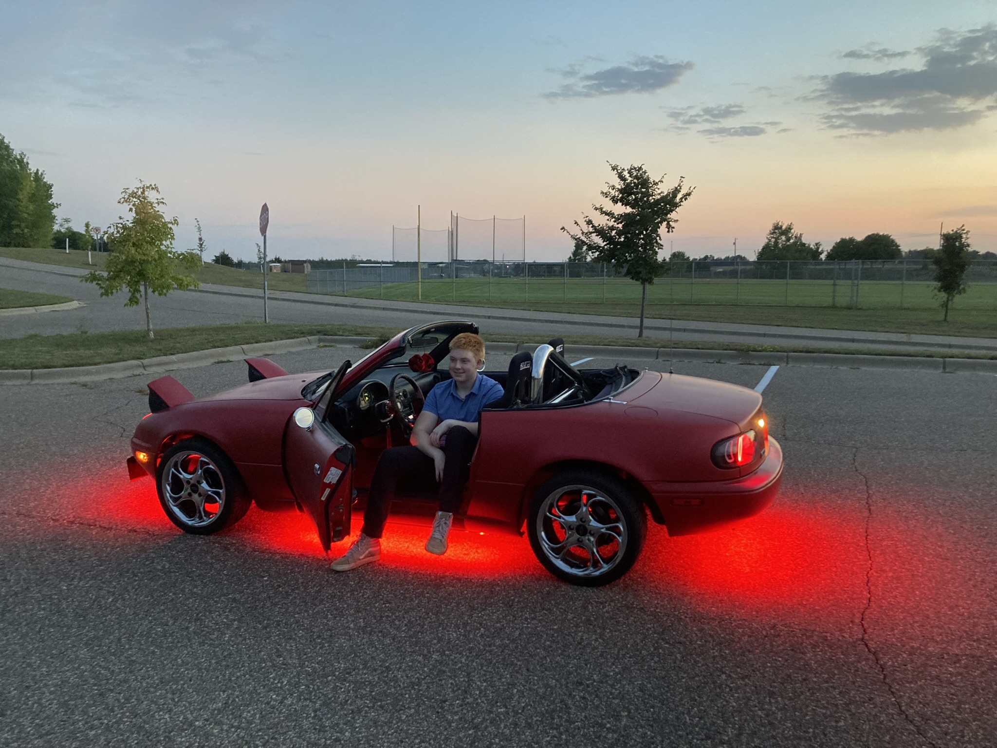 Hans sitting in his restored Mazda Miata at dusk